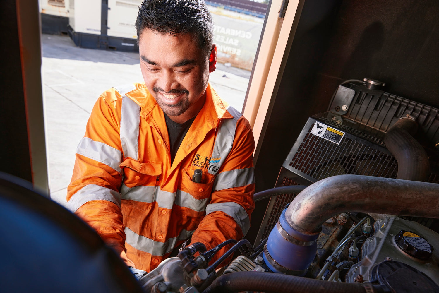 Generator engineer working with a smile on an sgh gen