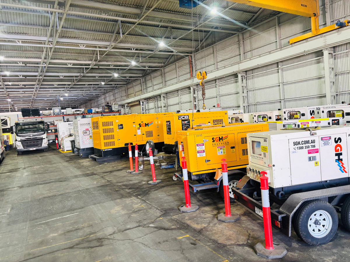 SGH rental generators, including trailer-mounted units, lined up inside the Newcastle depot warehouse.