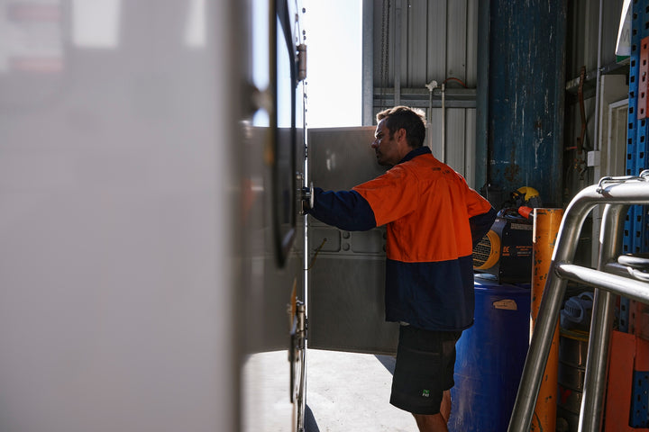 engineer working on generator in farm shed